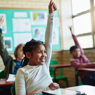 Child raising hand in classroom